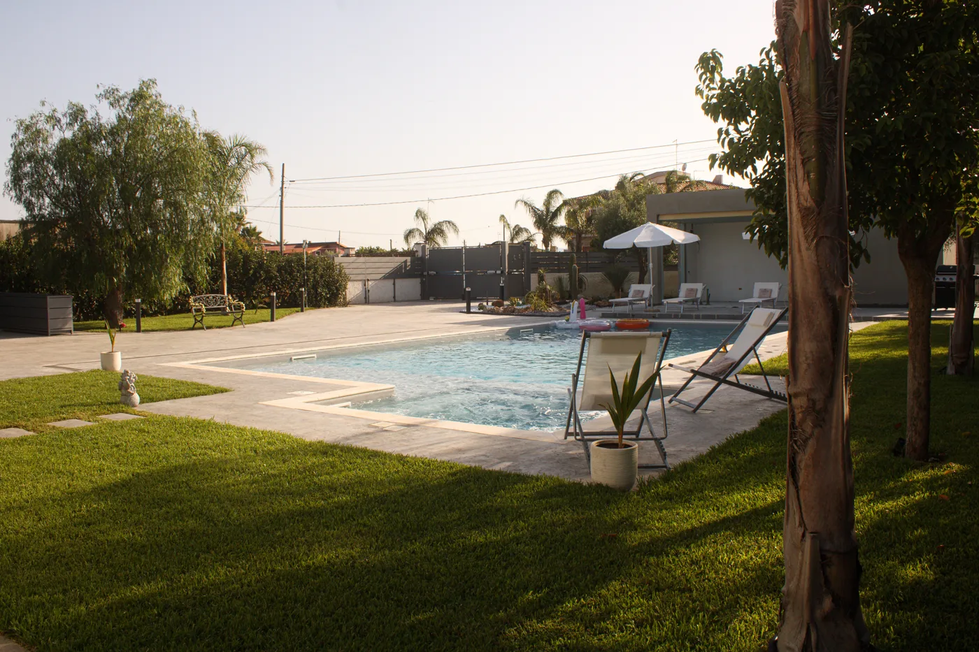 Piscina con lettini nel giardino
