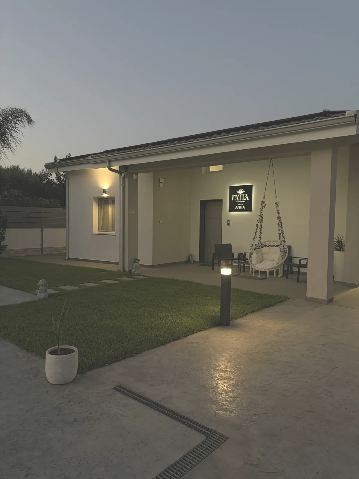 Villa Natìa — esterno al tramonto con insegna illuminata